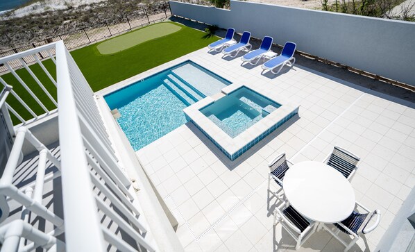 A rooftop pool area with a hot tub, lounge chairs, and a small table. - Oceanfront Home with Best Views & NEW Pool on the Beach (St Augustine)