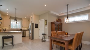 A modern kitchen with a central island, stainless steel appliances, and pendant lighting.