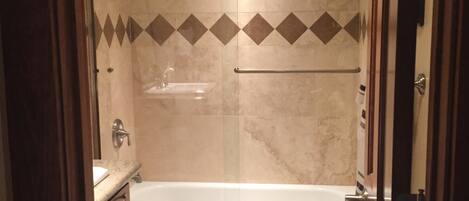 A bathroom with a bathtub, toilet, and vanity.