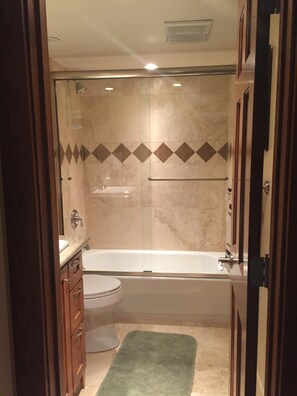 Tina con regadera, secadora de cabello, toallas, jabón