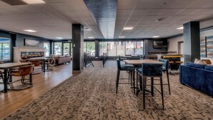 A spacious indoor area with multiple seating arrangements, including tables and chairs, and a fireplace. - Need an escape from summer heat? Cool down in our cozy condo! Summer dates open! (Breckenridge)