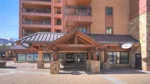 A hotel entrance with a sign reading "SHAVANO" and a sign for "RENTALS" to the left. - Need an escape from summer heat? Cool down in our cozy condo! Summer dates open! (Breckenridge)