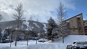 A hotel named "PeriGrine" with a view of snow-covered mountains in the background. - Newly Remodeled 2Bd, 2Ba/ Steps From The Super B-lift /ski rental/restaurant/bus (Frisco)