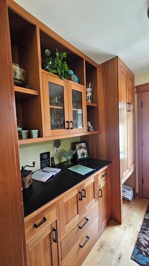 A kitchen with wooden cabinets, a black countertop, and various kitchen items.
