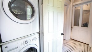 A laundry area with stacked washing machines and a white door.