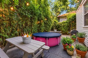 Un patio al aire libre con una mesa, un trampolín y plantas en macetas.