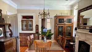 A traditional dining room with a long wooden table, matching chairs, and a chandelier.