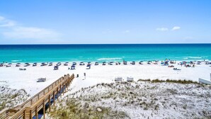 A beach with a wooden boardwalk leading to the water, white sand, and clear blue sky. - Stunning Oceanfront on Crystal Beach with 2 King beds. Beach service included. (Destin)