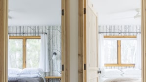 Due camere da letto con porte in legno, ognuna con una finestra e un comodino.