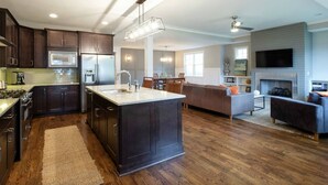 A modern kitchen with dark wood cabinets, a central island, and a built-in stove. - Walk to some of Nashville's best shopping ,dining and parks! Great for families (Nashville)