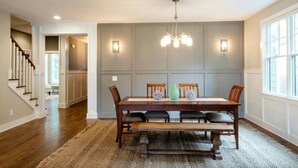 A dining room with a wooden table, four chairs, a bench, a chandelier, and a large window. - Walk to some of Nashville's best shopping ,dining and parks! Great for families (Nashville)