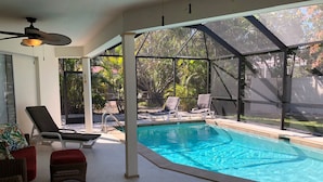 An indoor swimming pool with clear blue water, surrounded by lounge chairs and a ceiling fan. - Quick Walk To Beach, Restaurants, Shops, Movies. Updated, Spacious. Private Pool (Marco Island)
