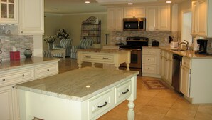 A spacious kitchen with white cabinetry, a granite countertop, and modern appliances including a microwave and oven. - Quick Walk To Beach, Restaurants, Shops, Movies. Updated, Spacious. Private Pool (Marco Island)
