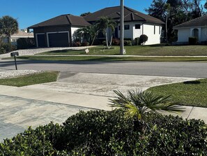 Une rue résidentielle bordée de maisons, avec une boîte aux lettres et une pelouse bien entretenue.