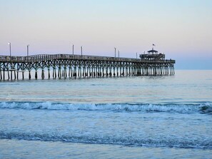 A pier extending into calm waters with a small structure at the end. - Pier Watch Villas-Sleeps-12 6br/4ba-Parking-Pools-WIFI-Near Pier-2 King Suites (North Myrtle Beach)