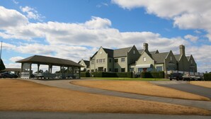 A large, multi-story building with a prominent entrance and a covered pavilion. - Legends Golf Resort - 2 Bedroom on ground floor, Wi-Fi included (Myrtle Beach)