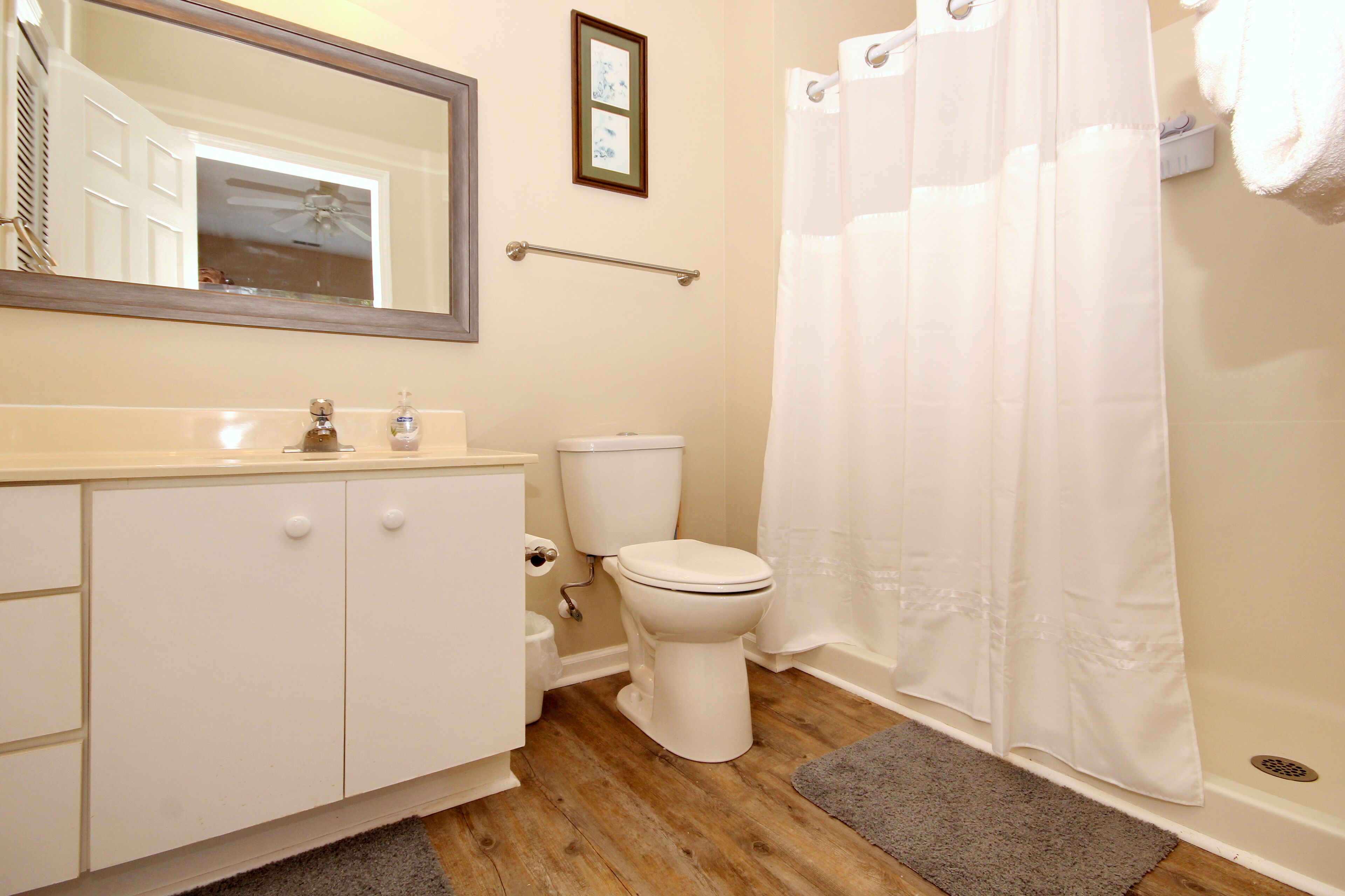 Une salle de bain avec des toilettes, un lavabo et un miroir.