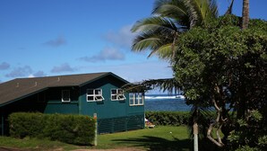 Una casa verde con vista al océano.