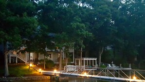 A waterfront property with a dock, a gazebo, and a house with a staircase leading to the dock.