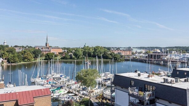 A marina with boats docked, a church in the background, and buildings along the water. - Beautiful Condo - Water View Near City Dock  (Annapolis)