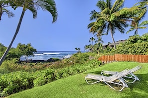 Relax in a serene outdoor setting surrounded by lush greenery and palm trees, with access to the ocean.