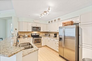 Enjoy cooking in this well-equipped kitchen with a double sink, microwave, toaster, coffee maker, and refrigerator.