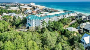 Oversigtsbillede af et kysthotel med flere bygninger, omgivet af frodig vegetation med udsigt over havet.