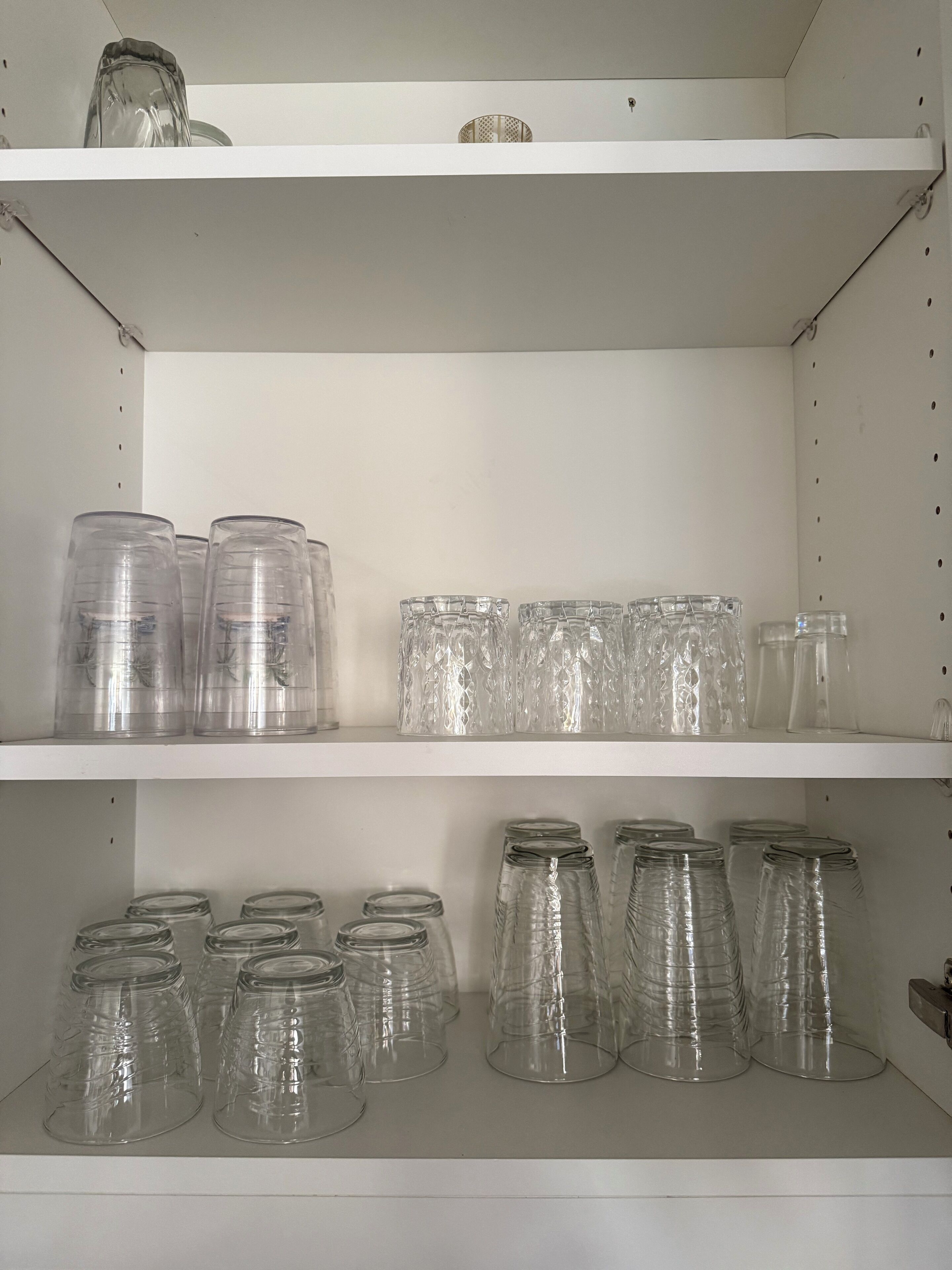 Un espace de rangement équipé d’étagères où sont disposés divers récipients transparents en verre.