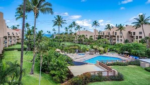 Un resort con varias edificaciones, piscina y palmeras.
