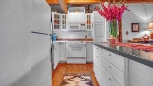 A kitchen with white cabinets, a built-in oven, and a microwave.