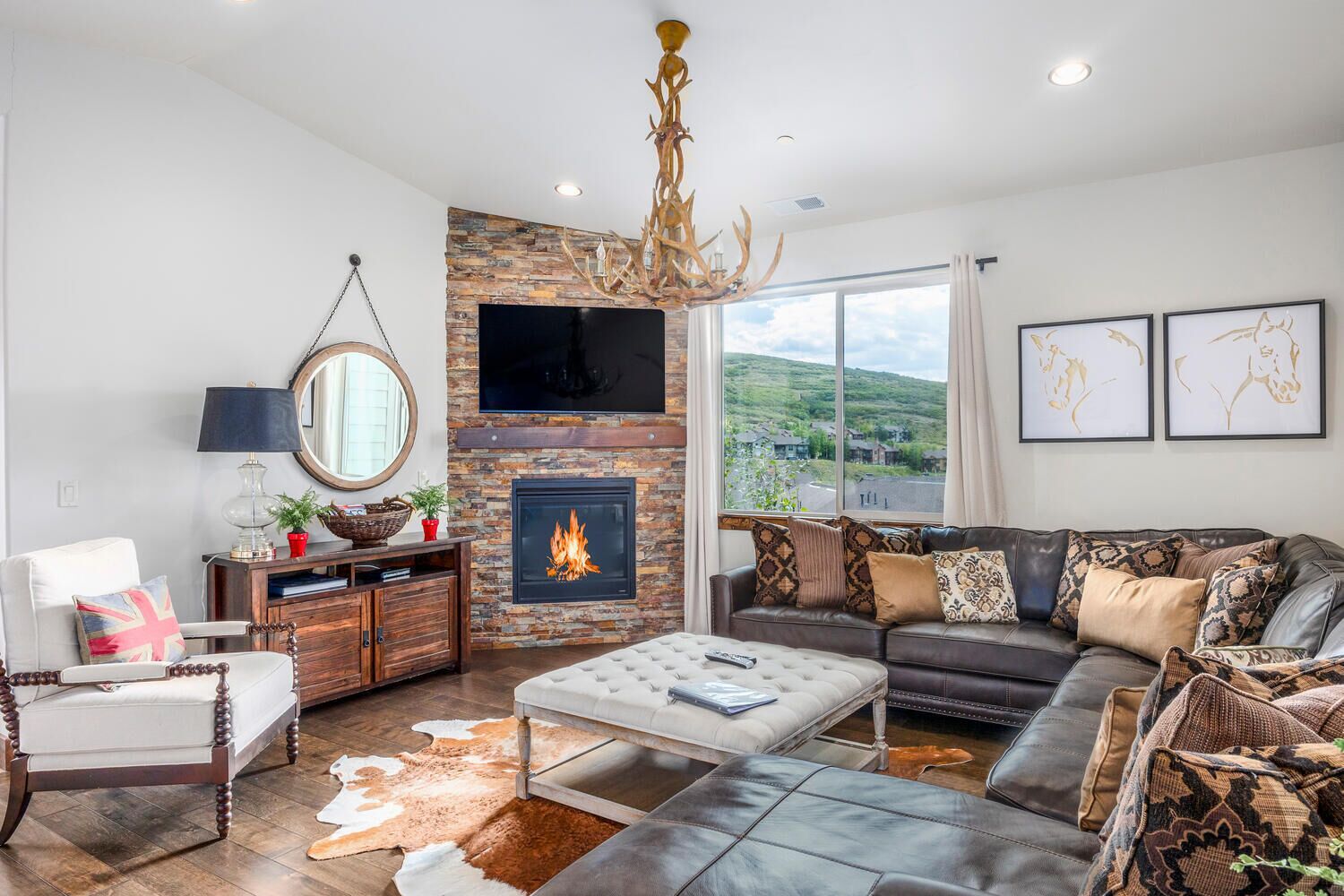 Una sala de estar moderna con chimenea de piedra, sofá de cuero y un amplio ventanal con vistas al exterior.