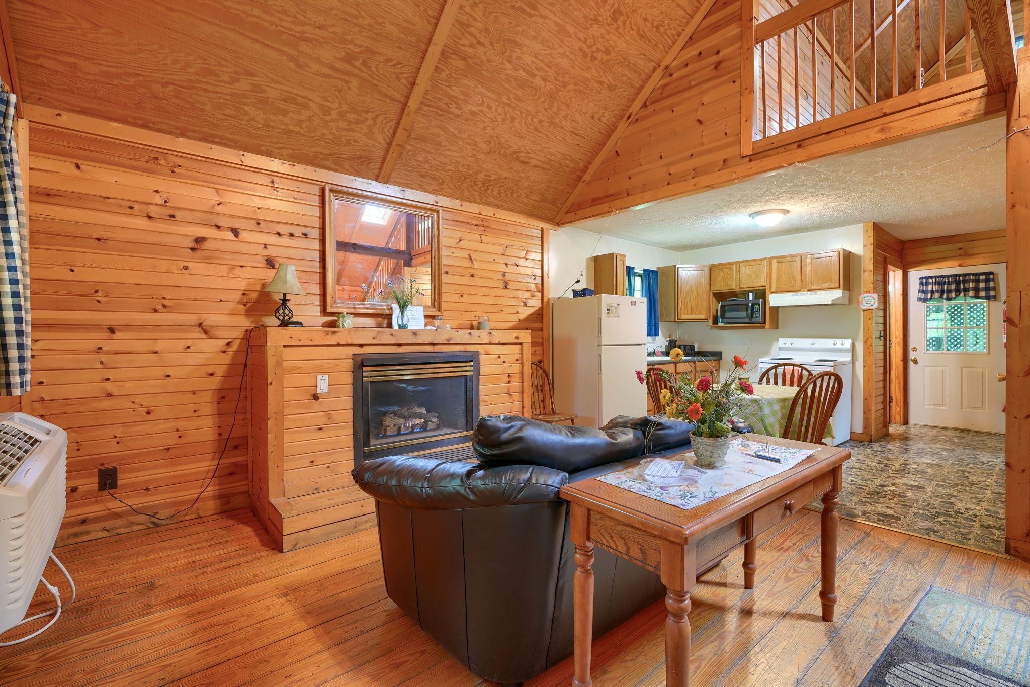 L’intérieur d’un chalet accueillant, avec une cheminée, une table à manger et un coin cuisine.