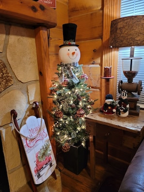Cozy cabin-style interior with a festive Christmas tree and warm ambiance.