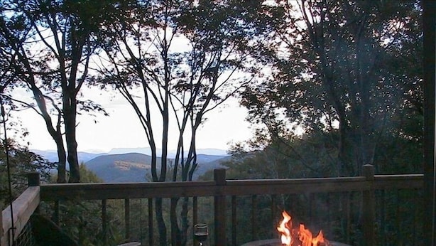 A deck with a fire pit and a chair, overlooking a mountainous landscape. - Million-Dollar Views, spectacular! Sugar Mountain Cabin 3 Bedrms 3 bath sleeps 7 (Sugar Mountain)