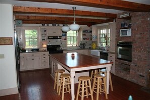 Enjoy casual dining at the central island with stools, surrounded by modern appliances and a rustic charm.