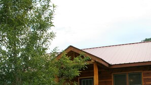 A wooden cabin with a porch and a staircase leading to the entrance.