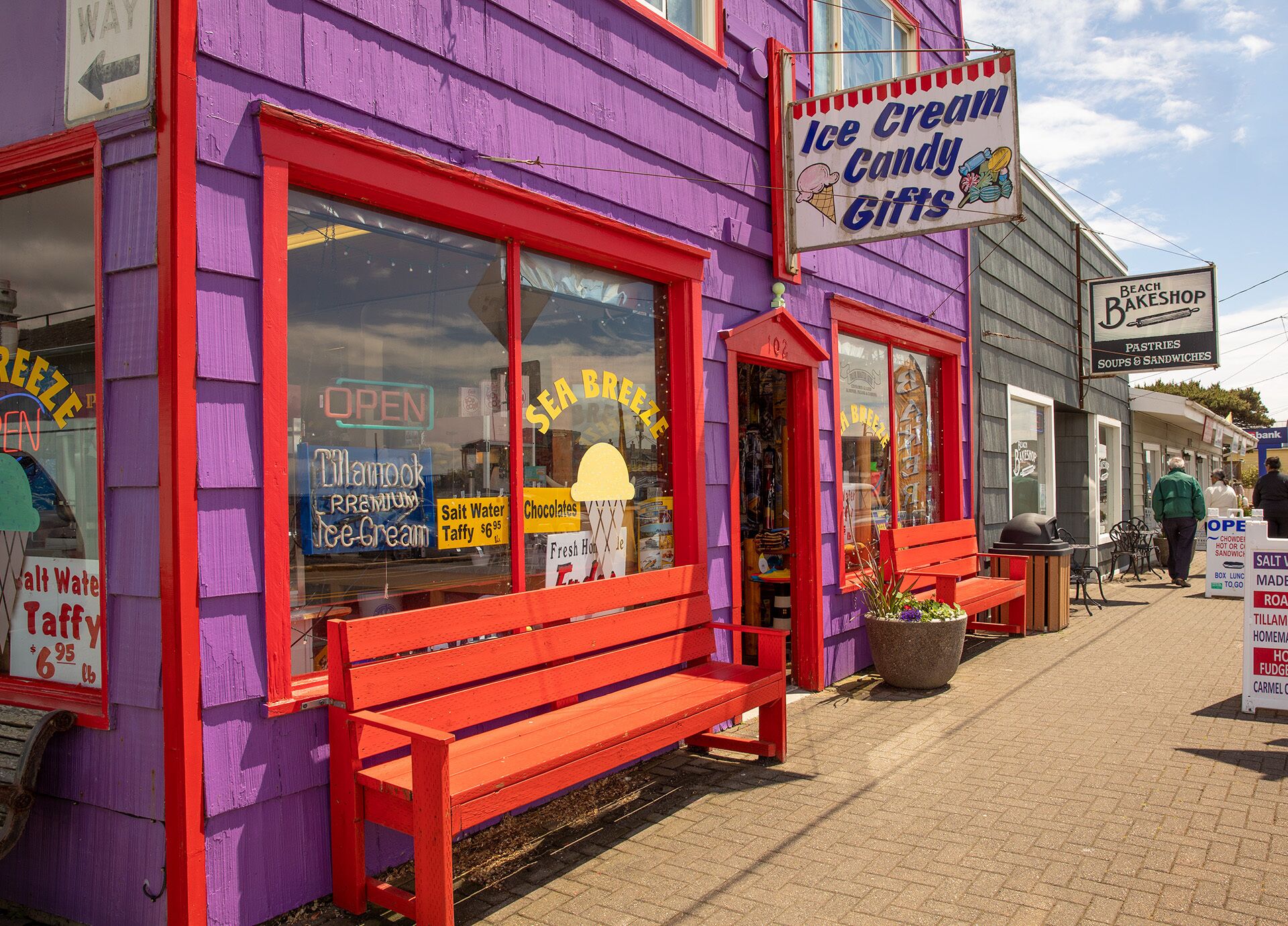 A storefront with a purple exterior and red trim, featuring signs for 'Sea Breeze' and 'Ice Cream Candy Gifts'.