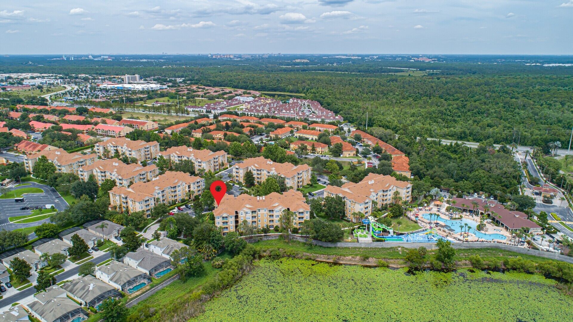 A residential area with apartment buildings, a swimming pool, and a park.
