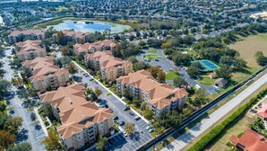 A residential area with apartment buildings, a parking lot, and a tennis court.