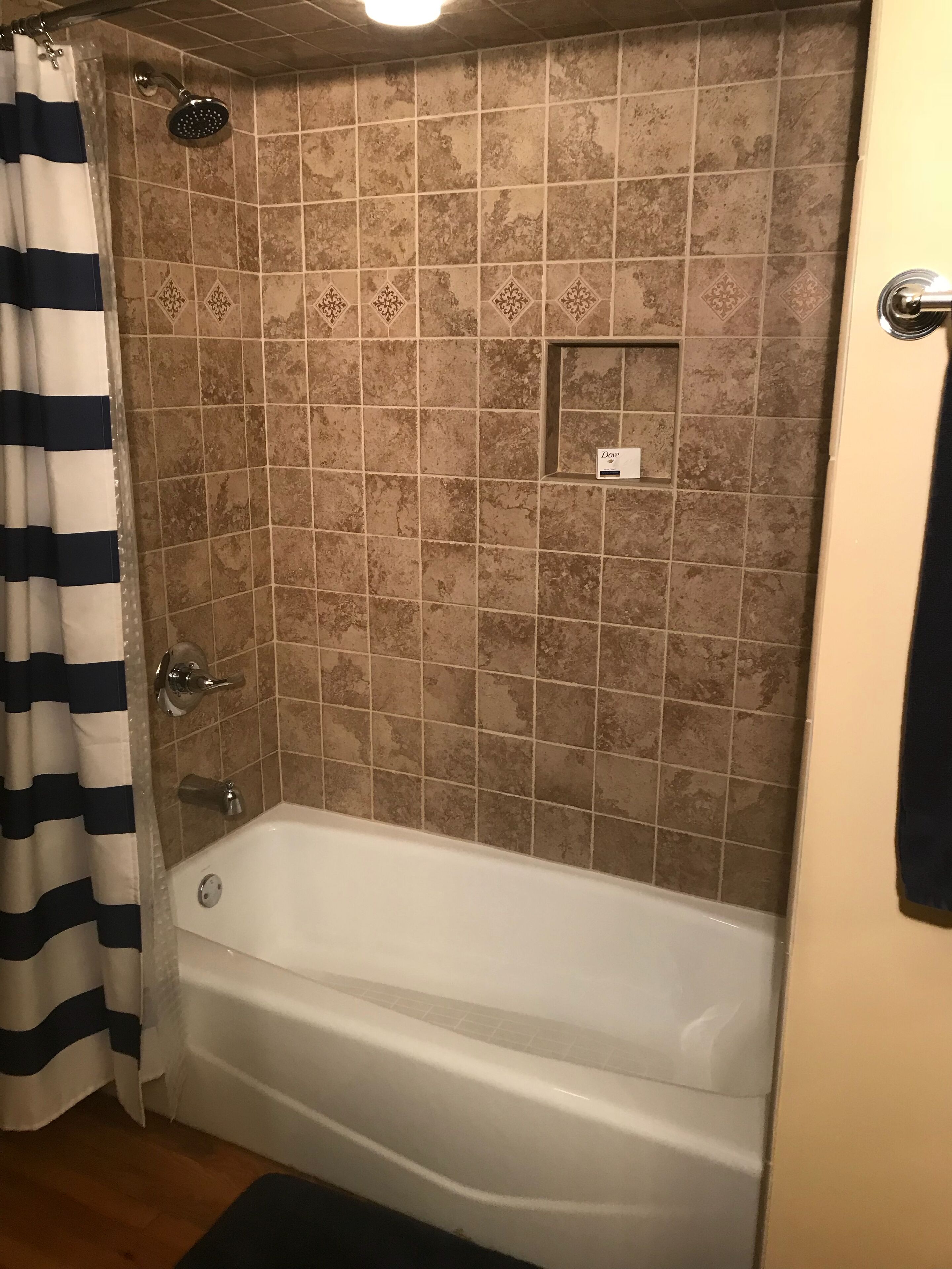 Un baño con bañera, ducha y paredes de cerámica.