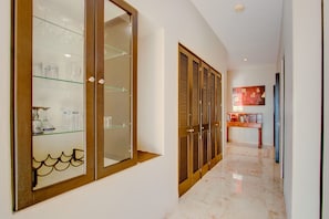 Stylish hallway with a glass-fronted cabinet, wooden doors, and polished floors.