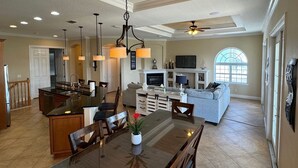 A spacious kitchen with a central island, dining area, and a cozy living space with a fireplace. - 4 King beds and En Suite Bathrooms - Ocean & Lake view, Elevator, 2 heated pools (Palm Coast)