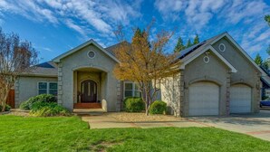 A two-story house with a front porch, a garage, and a well-maintained lawn.