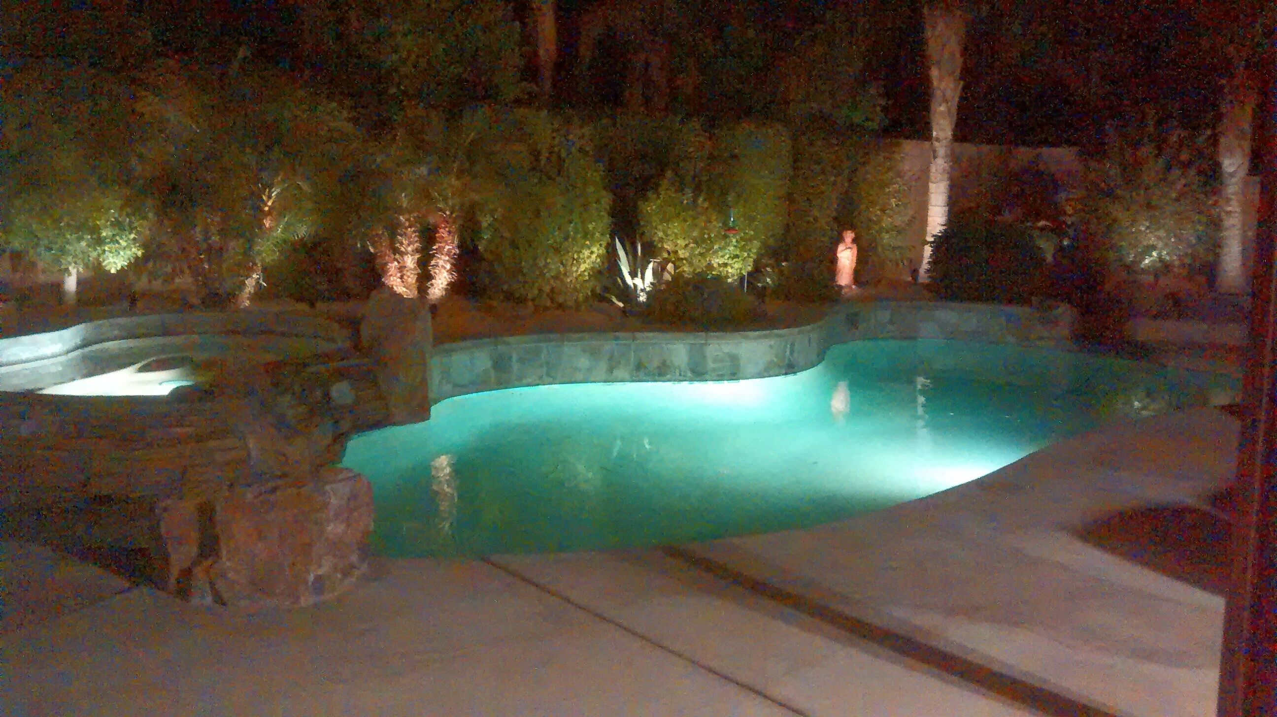 A swimming pool with a stone border and a stone ledge.