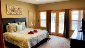 A bedroom with a bed, a desk, and a painting on the wall. - RIVER FRONT front property with Hot Tub! Bring the dogs! (Bend)