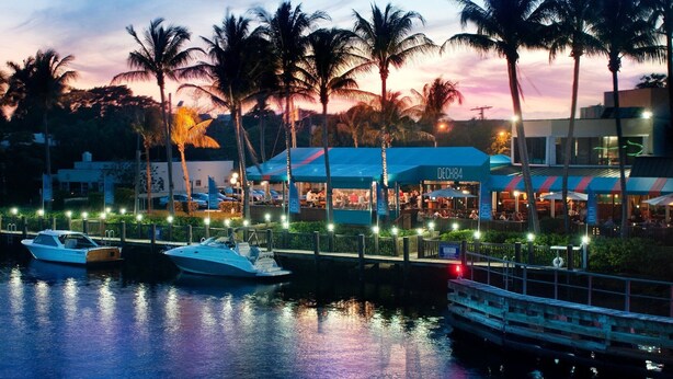 A waterfront restaurant with a view of the water, docked boats, and palm trees. - Completely Renovated And Beautifully Furnished Condo In Delray Beach... (Delray Beach)
