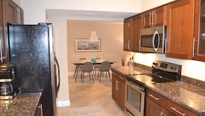 A modern kitchen with granite countertops, stainless steel appliances, and wooden cabinets. - Completely Renovated And Beautifully Furnished Condo In Delray Beach... (Delray Beach)