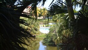 A view of a waterway with palm trees and a building in the background. - Completely Renovated And Beautifully Furnished Condo In Delray Beach... (Delray Beach)