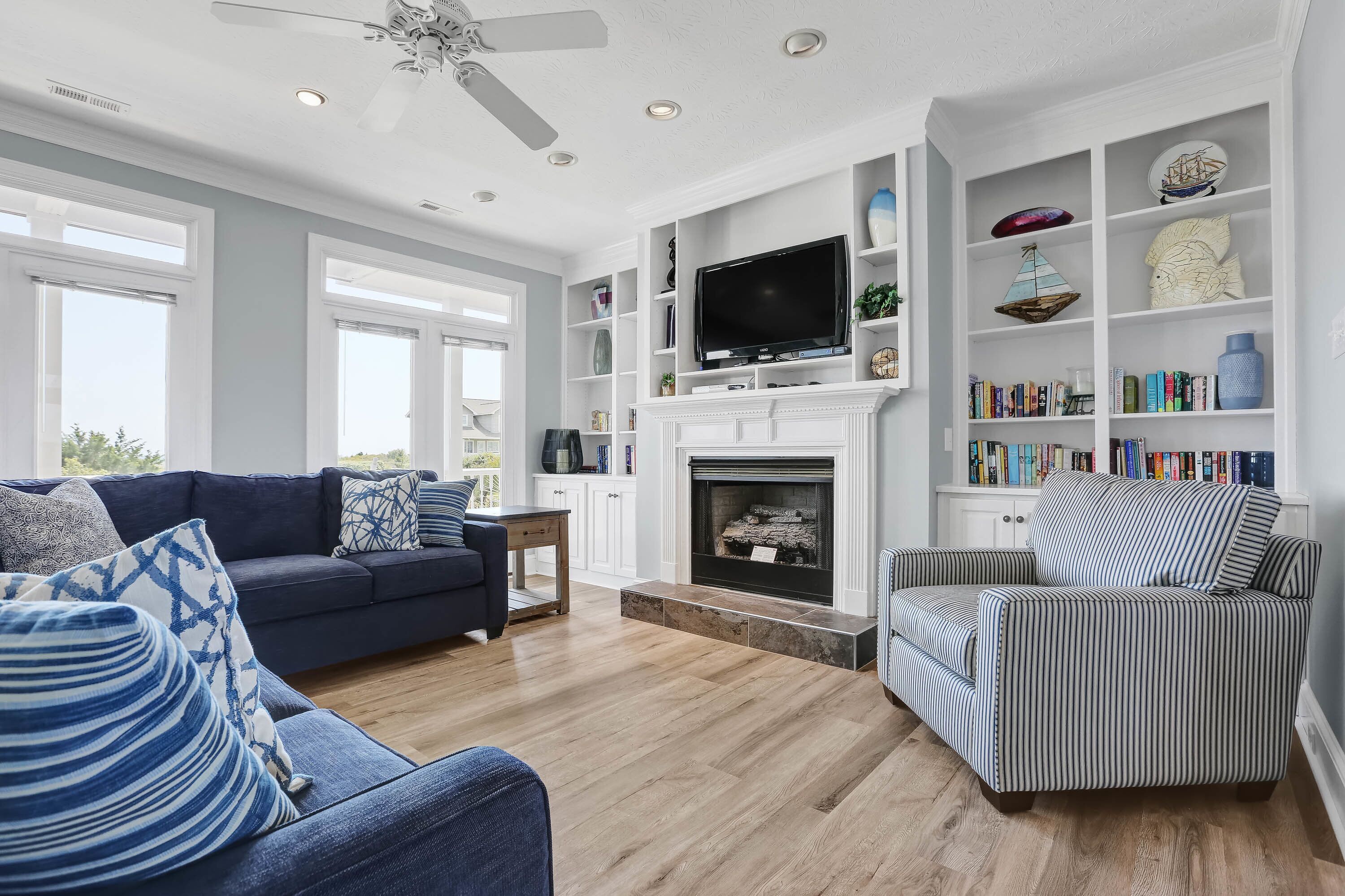 A living room with a fireplace, a television, and a bookshelf.