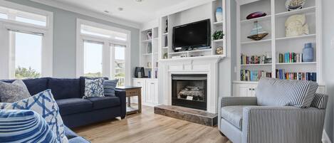 A living room with a fireplace, a television, and a bookshelf.